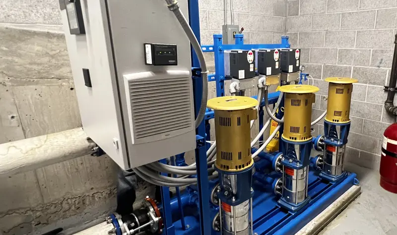 Booster pump package with pumps and controls in a mechanical room