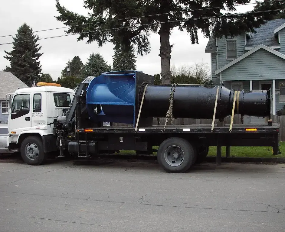 Large cylindrical pump assembly secured on a service truck